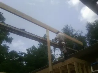 Carpenter setting a ridge beam over a new addition frame — Ice Dam Removal by Roofing Brothers in South Portland