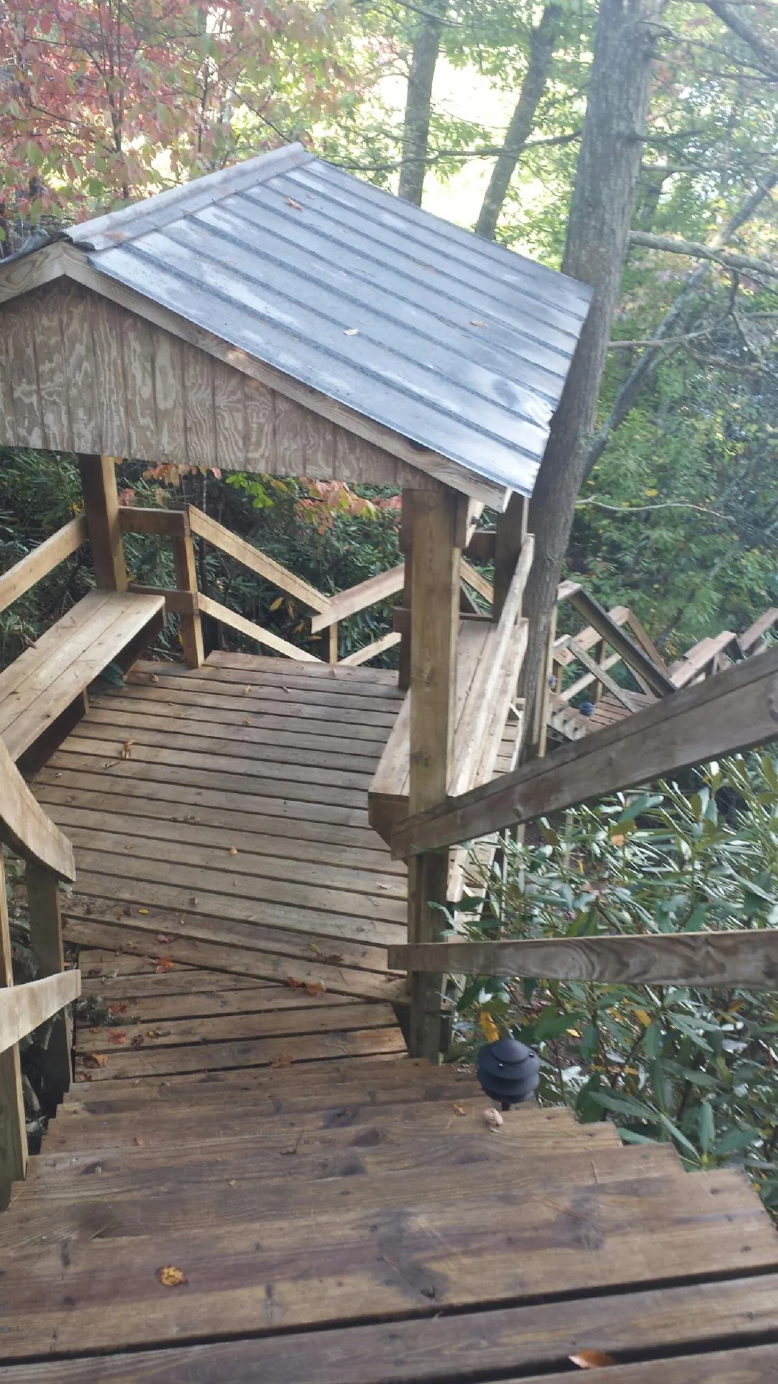 Metal roofed shelter over wooden steps on a wooded walkway — Skylight Repair & Installation work by our crew in South Portland