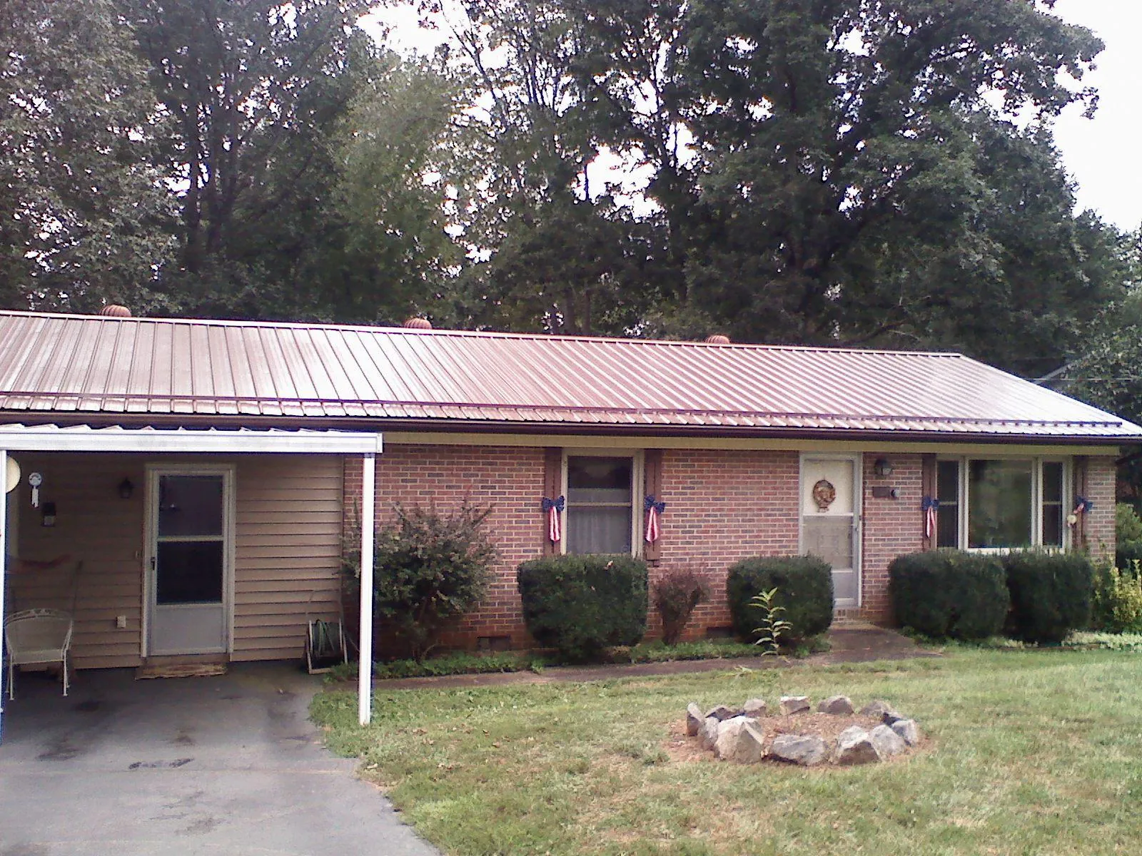 Bronze metal roof and carport on a brick ranch home — Roof Repair work by our crew in South Portland